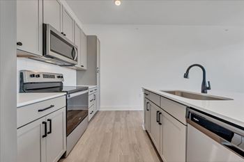 A kitchen with white cabinets and stainless steel appliances at Luxe 360 on Centerpointe Apartments, Midlothian